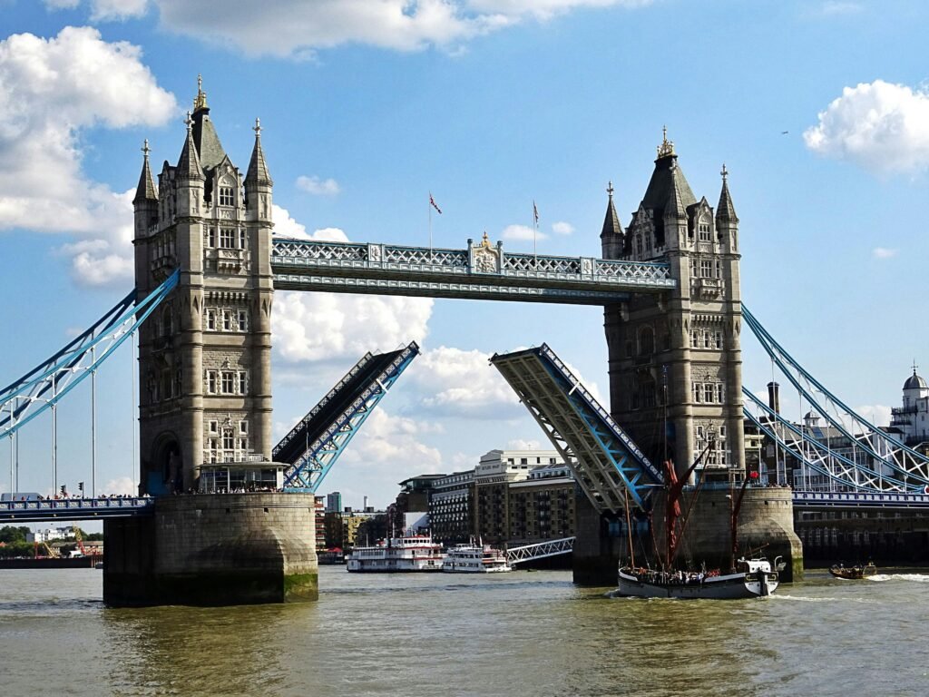 Iconic Tower Bridge in London with raised bascules over the River Thames on a sunny day.